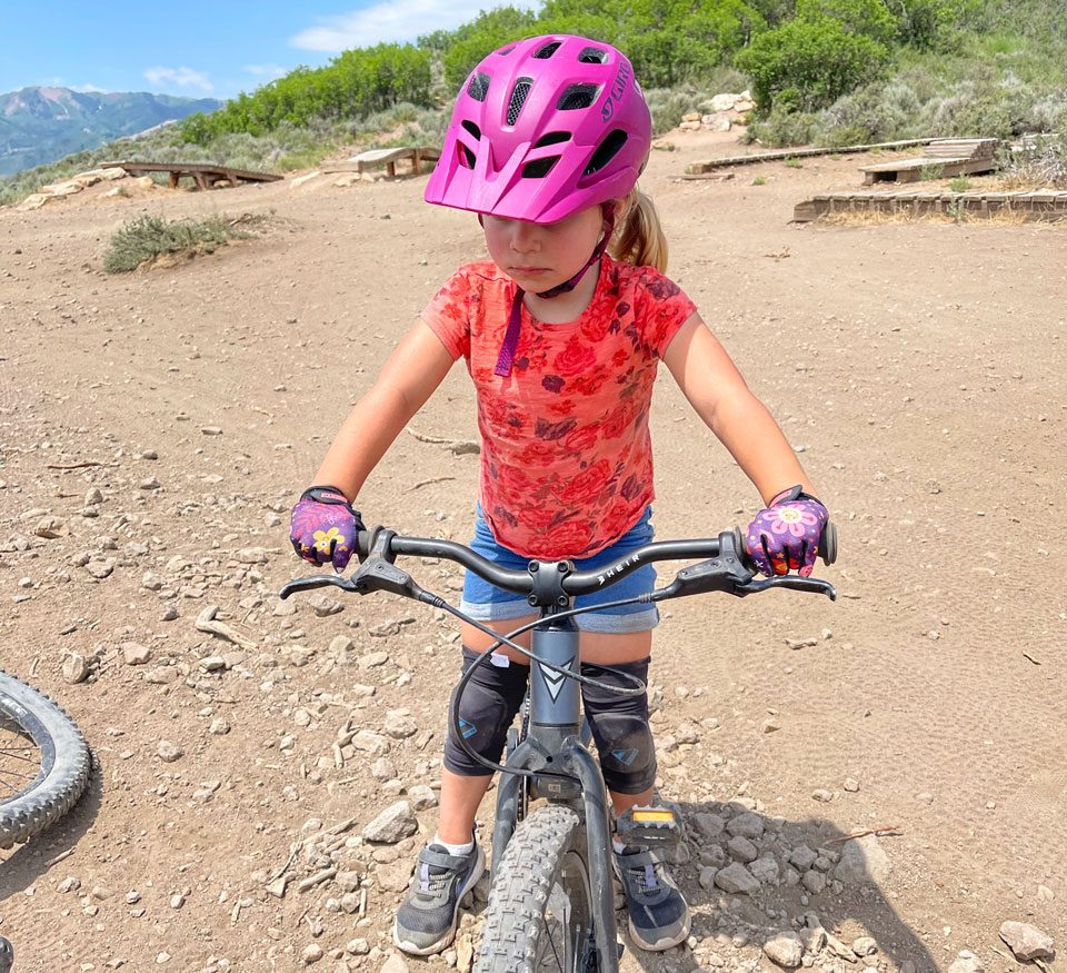 3 year old wearing zippyrooz gloves at a mountain bike park