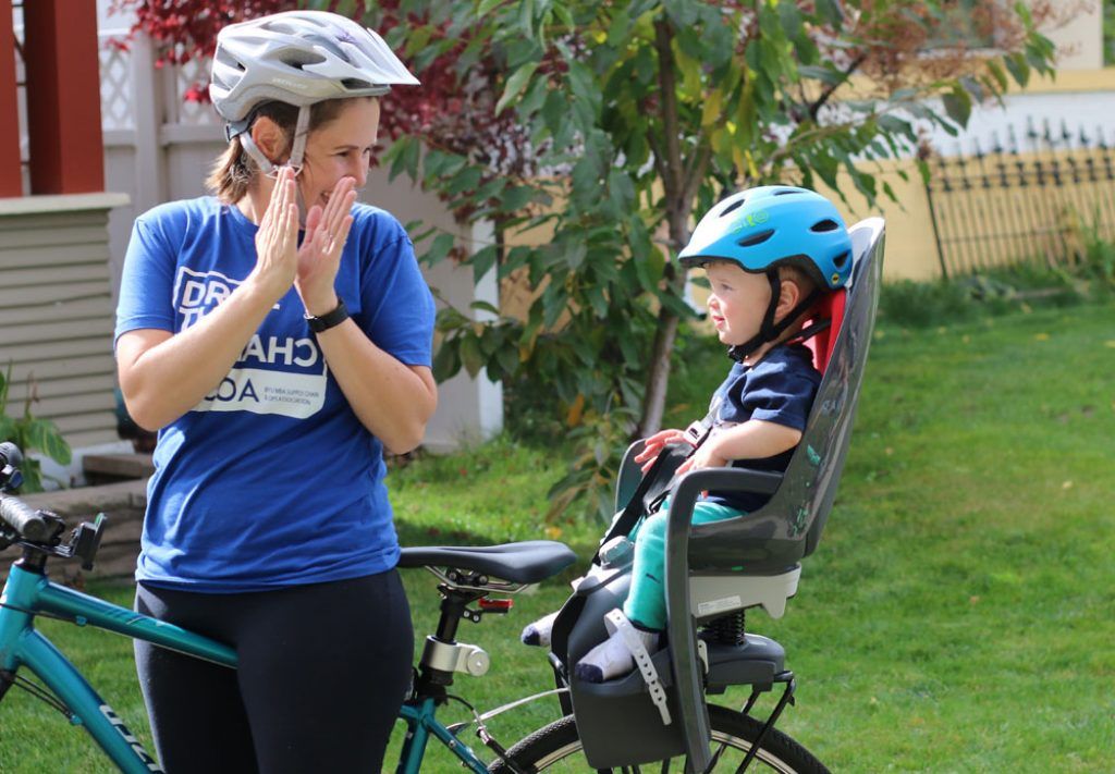Mutter fährt mit dem Hamax Caress Fahrradkindersitz für die Gepäckträgermontage