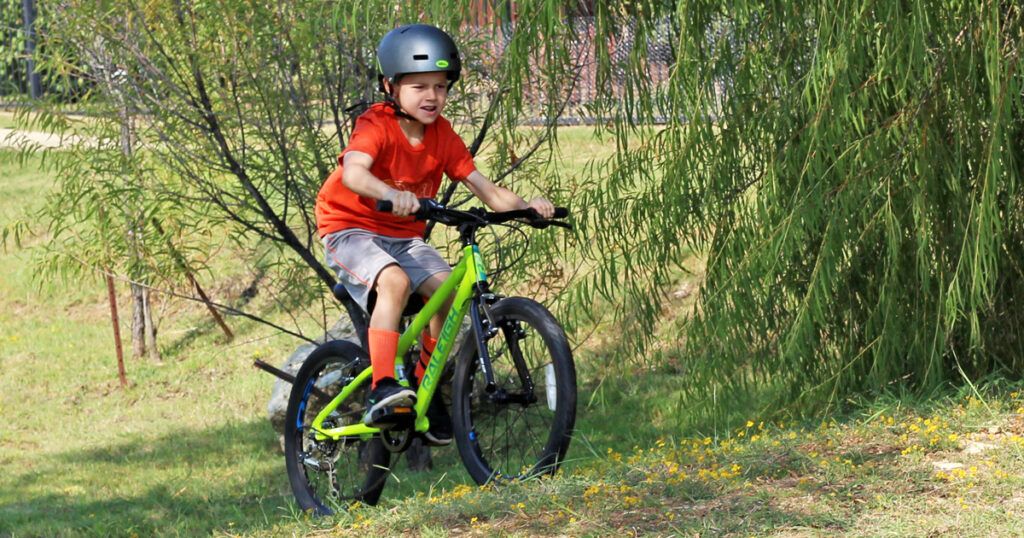 boy riding a green raleigh rowdy 20 inch bike