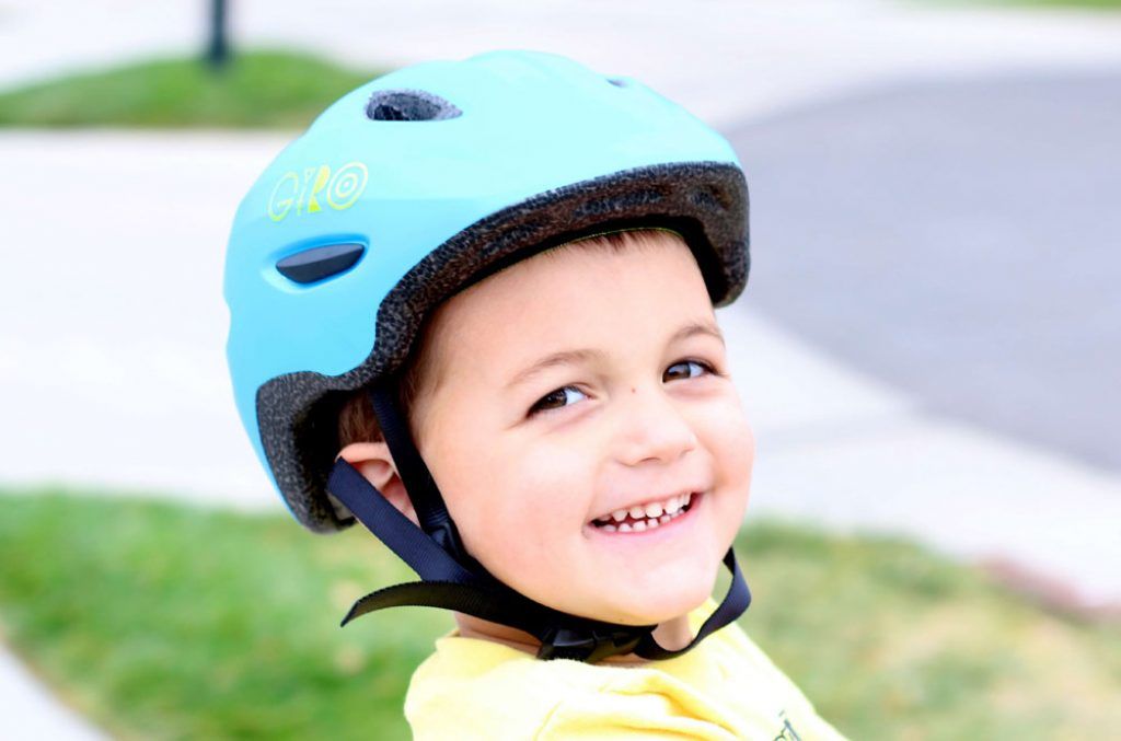 young boy wearing a blue giro scamp bike helmet