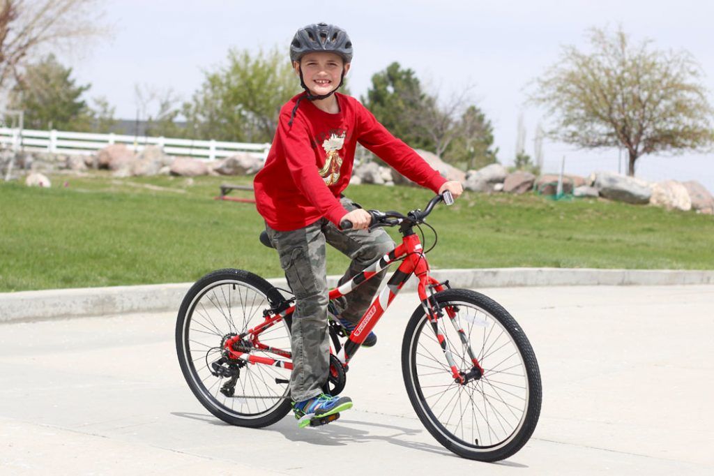 boy riding a red Guardian 24 inch bike