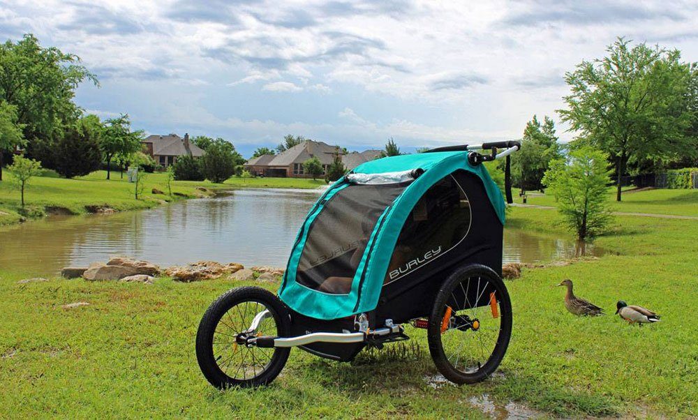 burley x bike trailer in jogger mode in front of a lake