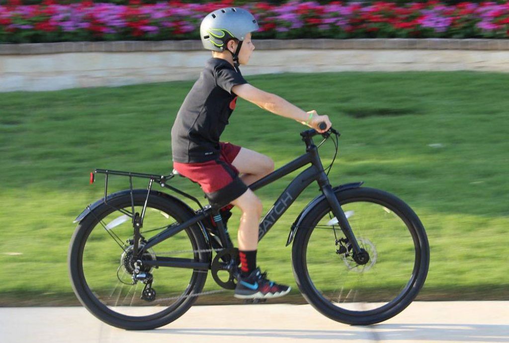 boy riding a black batch commuter 24 inch bike