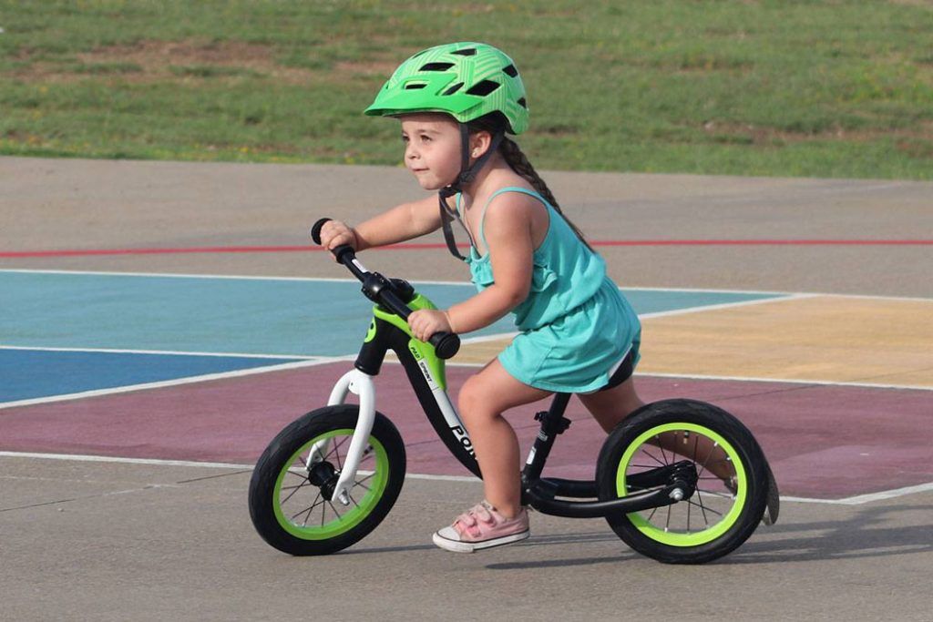 toddler girl riding the royalbaby pony green and black balance bike