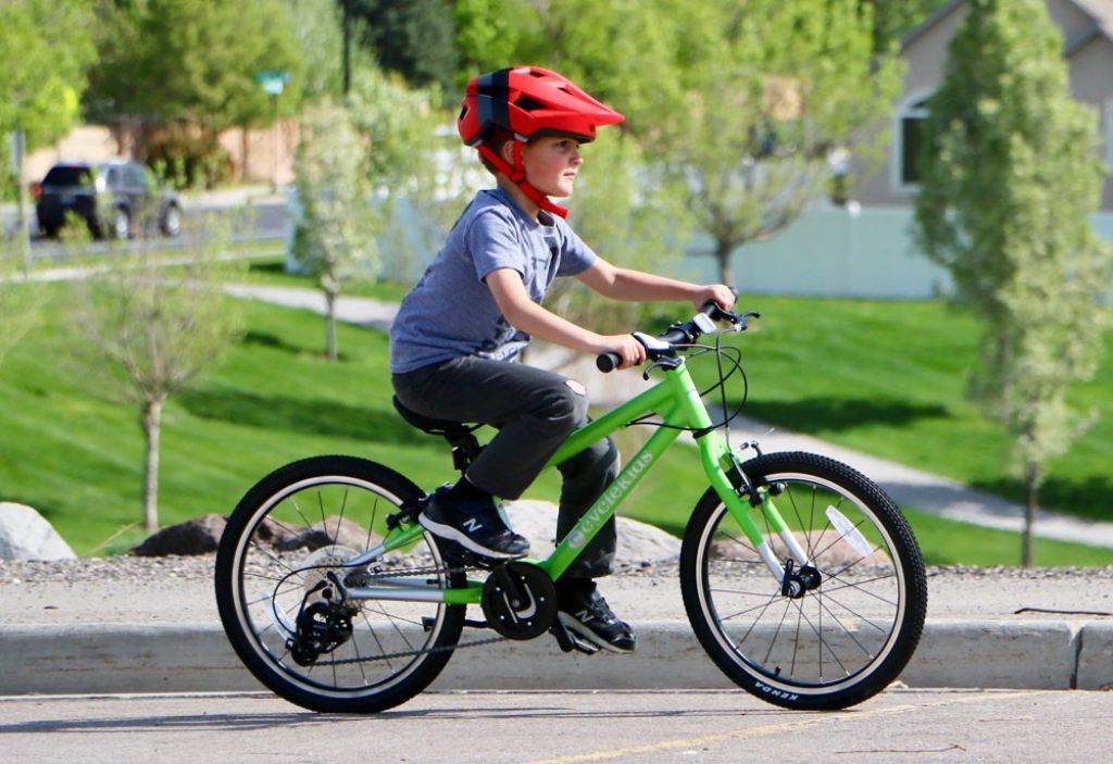 boy riding a green cyclekids 20-inch bike