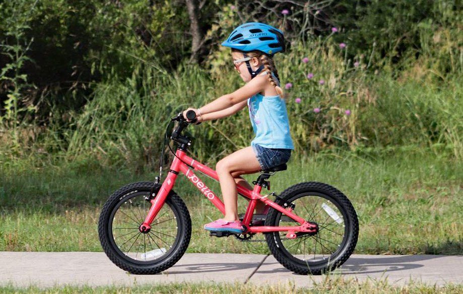 5 year old riding a pink pello revo kids 16 inch bike