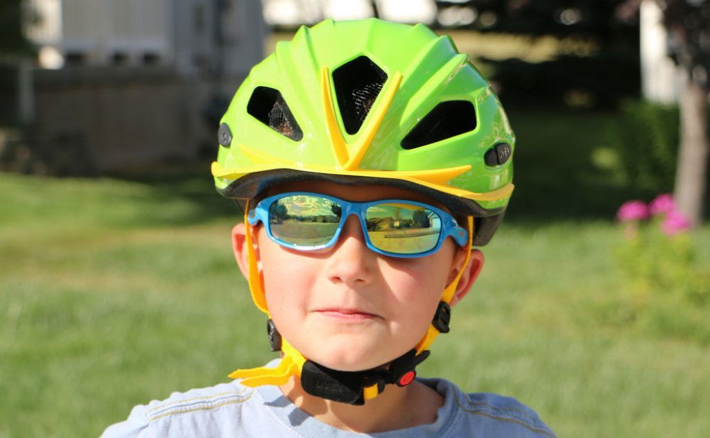young boy wearing a green Uvex Quatro bike helmet