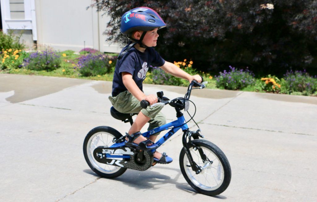 young boy riding a blue joey 2.4 14 inch kids bike