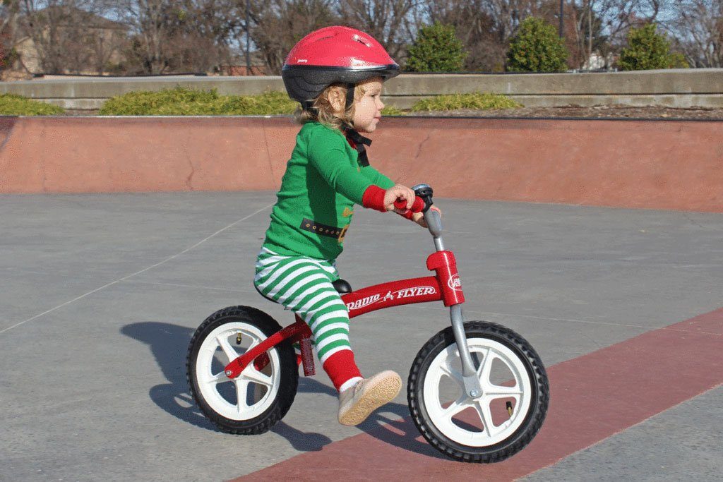 young girl riding a radio flyer balance bike