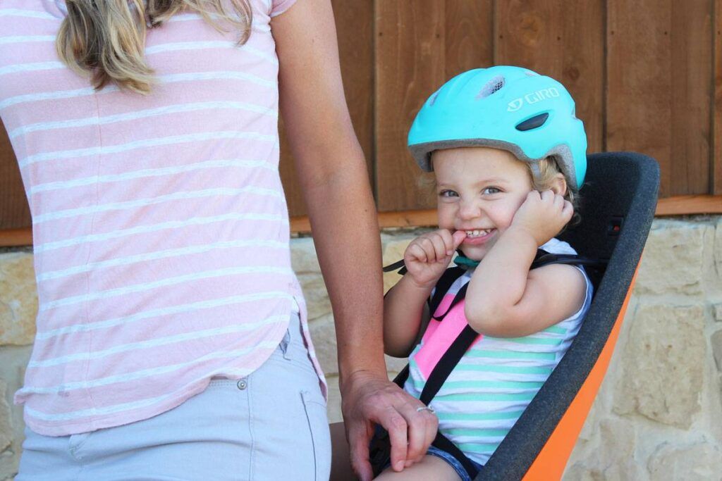 Toddler riding in child bike seat while wearing XS Giro Scamp