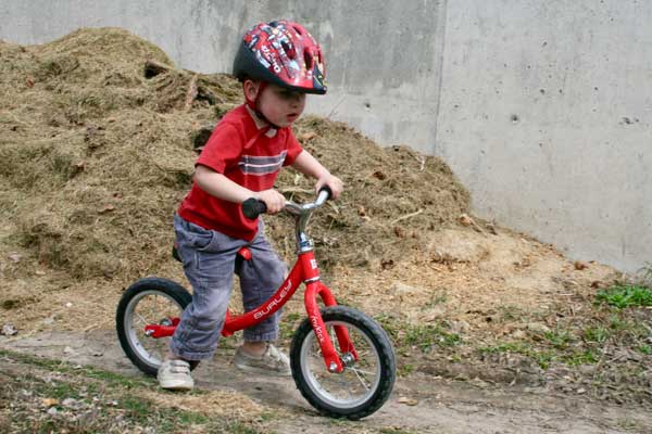 Toddler riding Burley MyKick balance bike in red