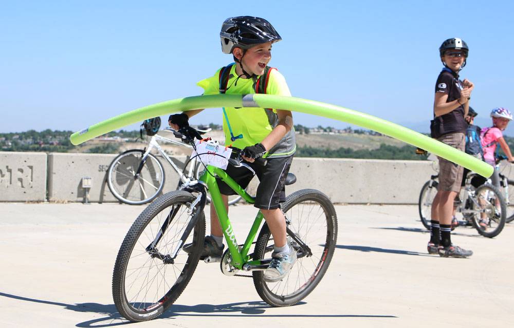 8-year-old playing pool noodle limbo on his bike