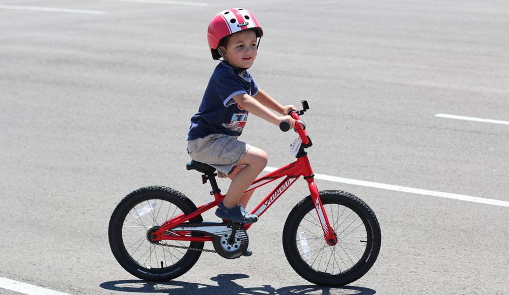 boy riding a red specialized riprock 16 inch bike
