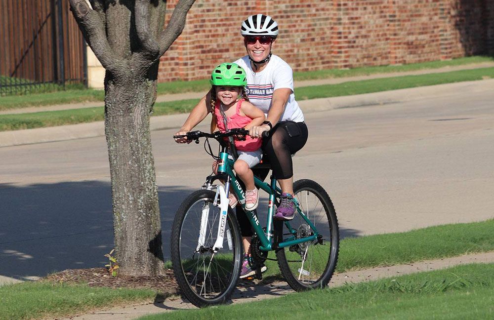 mom riding with her daughter on the Tyke Toter