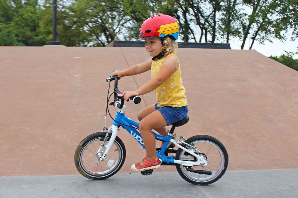 3 year old girl riding blue woom 2 14 inch bike at the skatepark