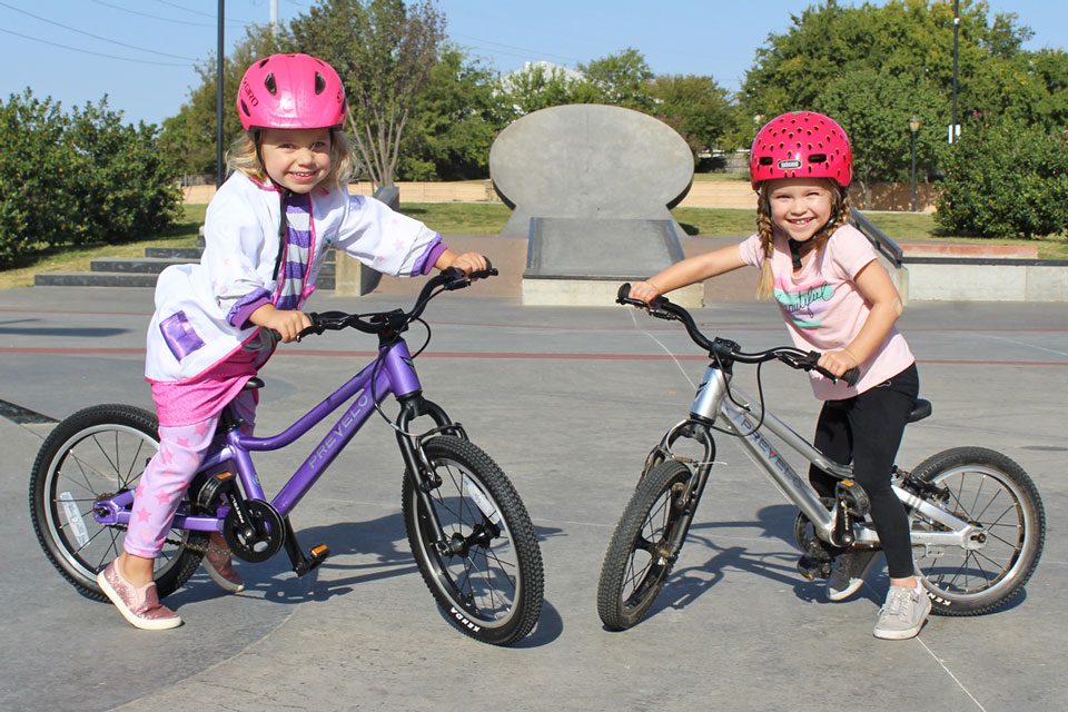 Two girls on purple and silver Prevelo alpha girls bikes. 