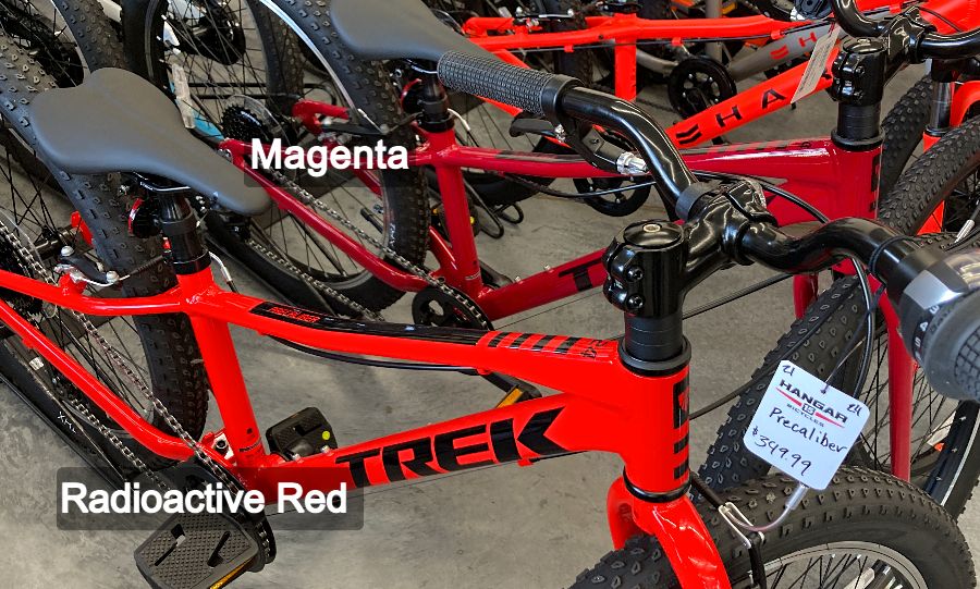 A Trek Precaliber radioactive red next to a Magneta colored bike