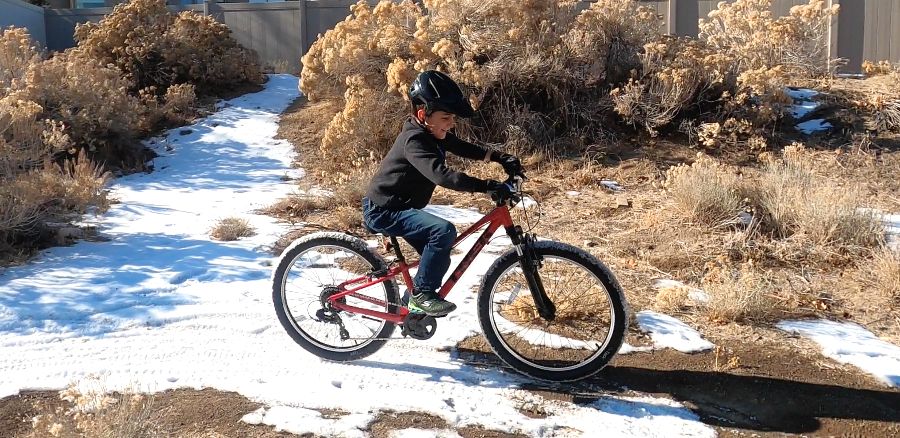 boy riding the Trek Precaliber 24 through dirt and snow