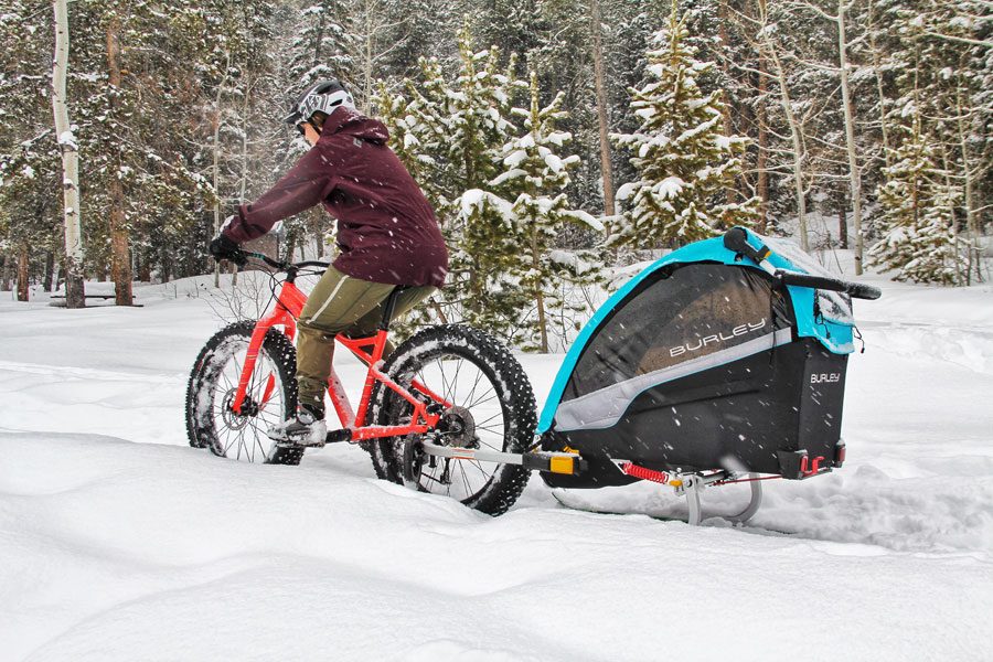 Woman pulling Burley trailer with attached Burley Skit Kit while riding her fat bike