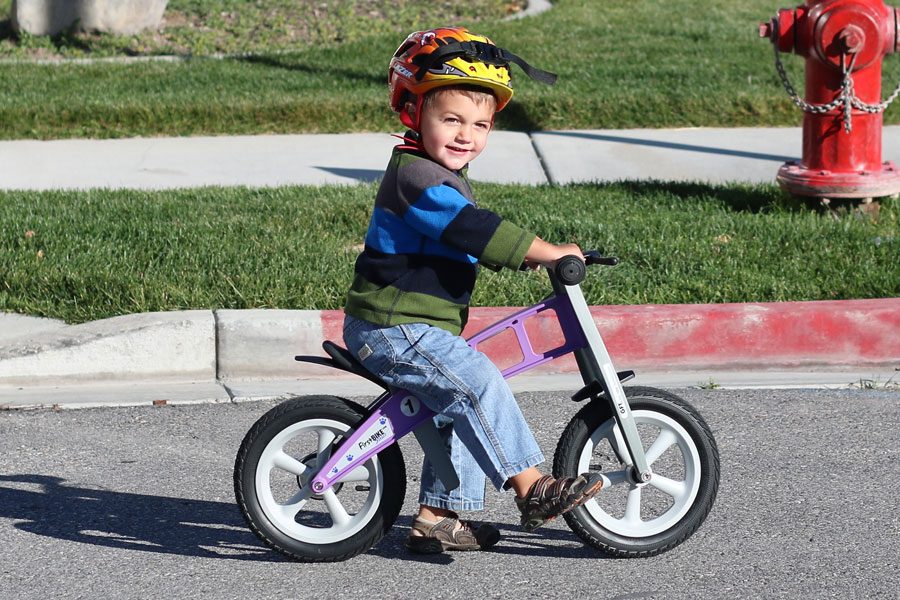 toddler riding FirstBIKE street balance bike on the pavement