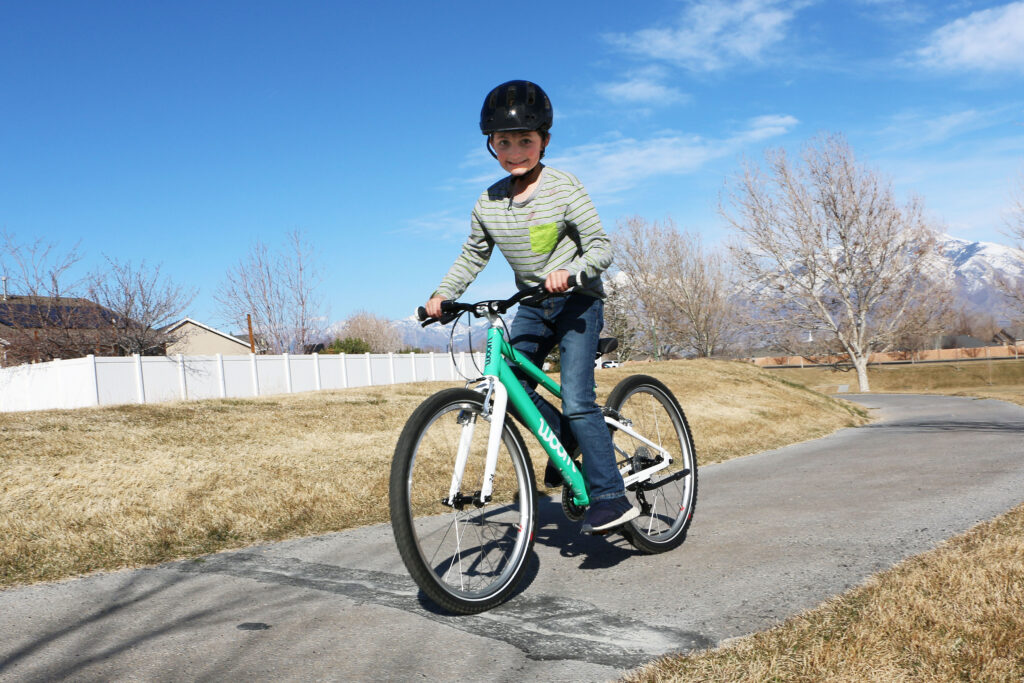 boy riding mint woom bikes 5 on paved path