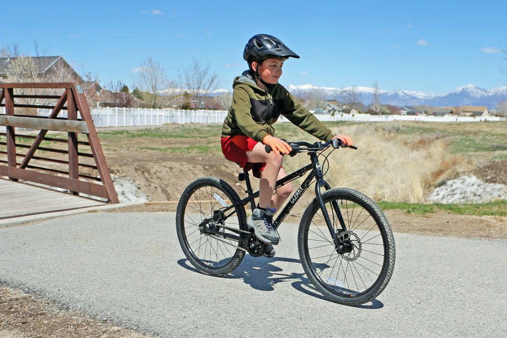 boy riding the cleary meerkat 24 inch bike on a paved bike trail