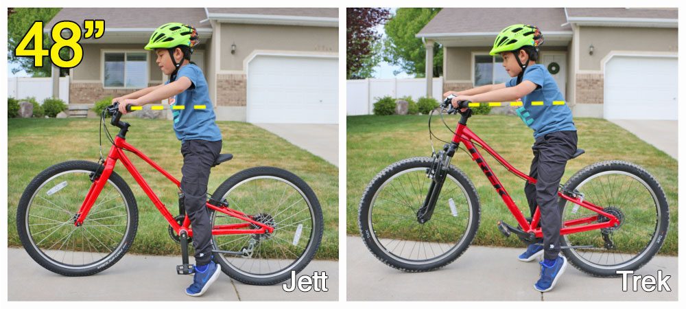 7 year old rider standing over the Specialized Jett 24 inch bike.  the bike is too big for him