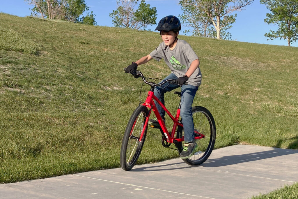 boy riding the specialized jett on a paved bike trail