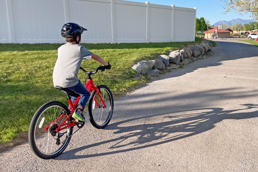 boy riding the Specialized jett down a paved bike path
