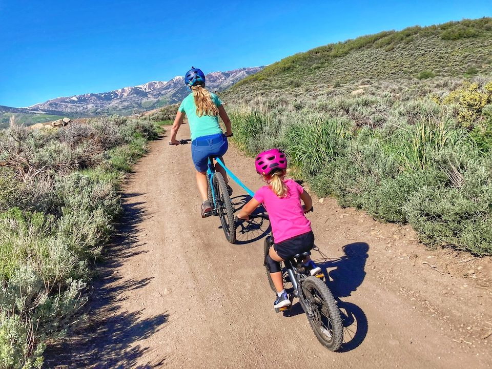 Child being towed by mom on her mountain bike - using the Kids Ride Shotgun tow rope