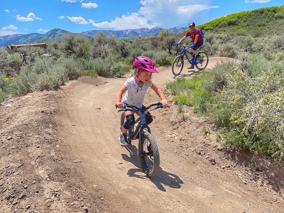 Dad and daughter on the trail, girl is riding 16 inch mountain bike by Prevelo