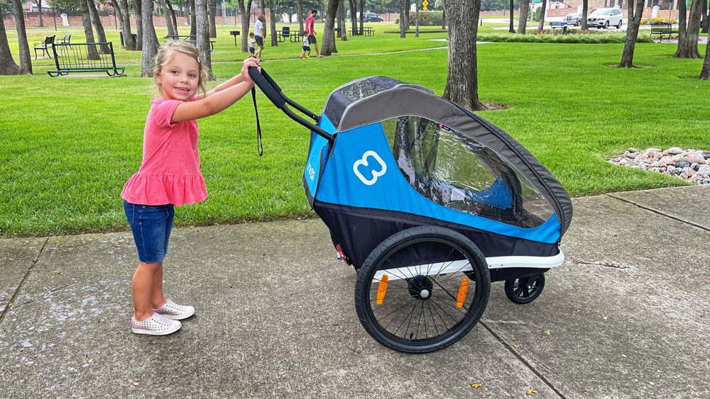 Toddler pushing her Hamax Traveller stroller