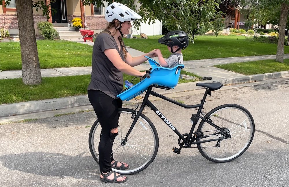 mom riding the Decathlon Btwin Riverside womens hybrid bike with a iBert seat