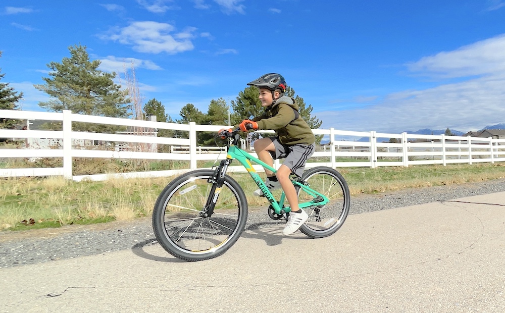 young rider riding the Polygon Premier XC 24 inch bike on a paved bike trail