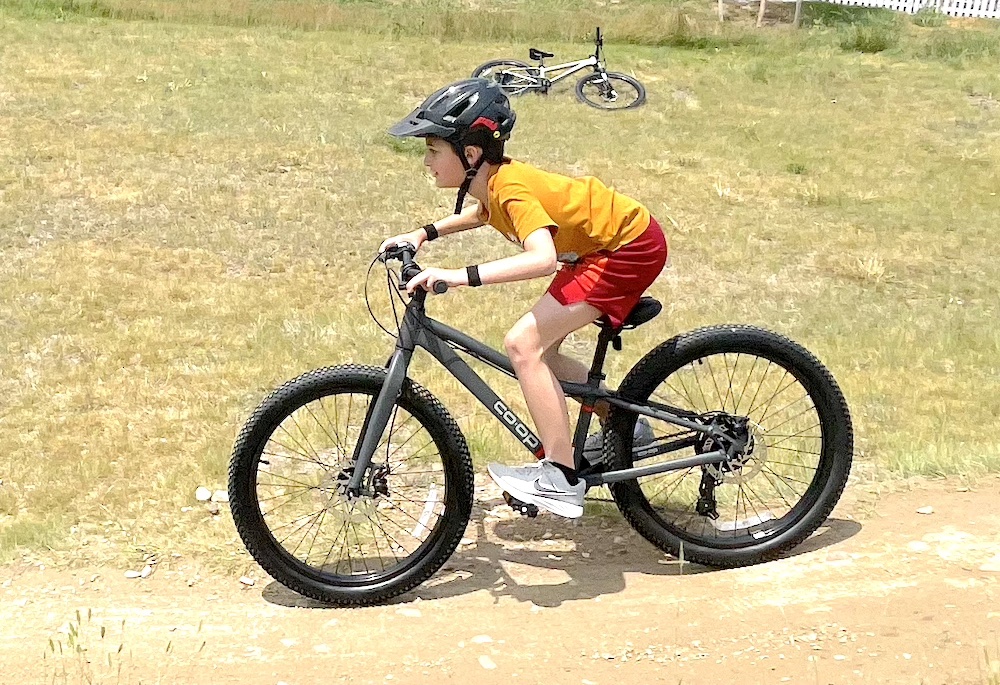 9 year old boy riding REI Co Op Cycles REV 24 Plus recreational mountain bike
