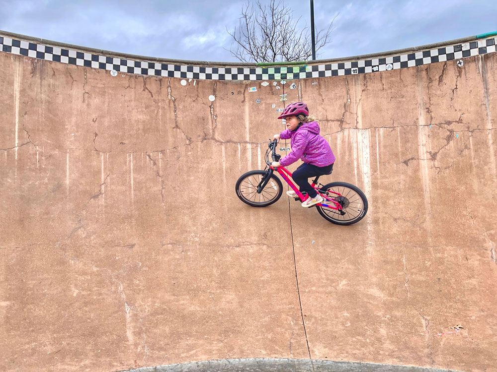 5 year old girl riding pink Prevelo Alpha Three high in a skate bowl