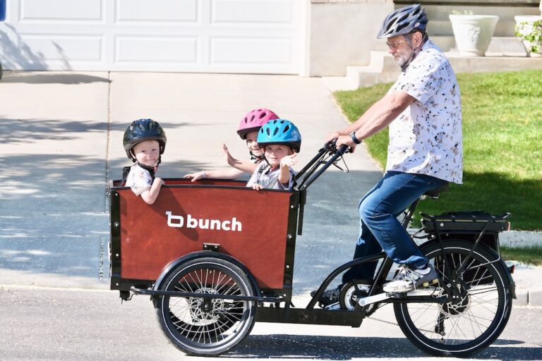 grandpa hauling grandkids in the bunch bike