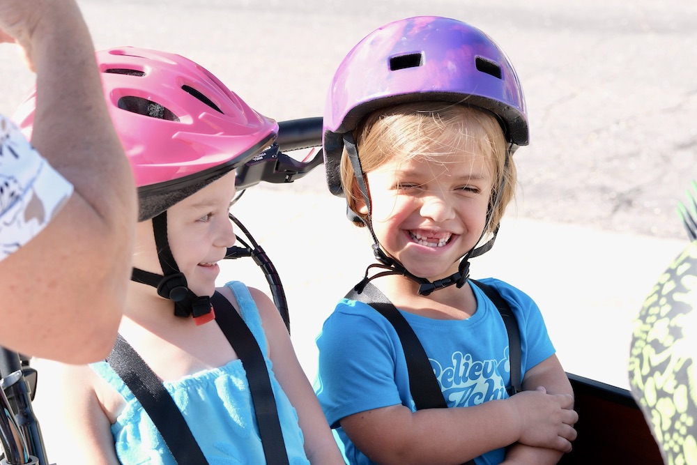 two girls smiling while sitting in the Bunch Bike