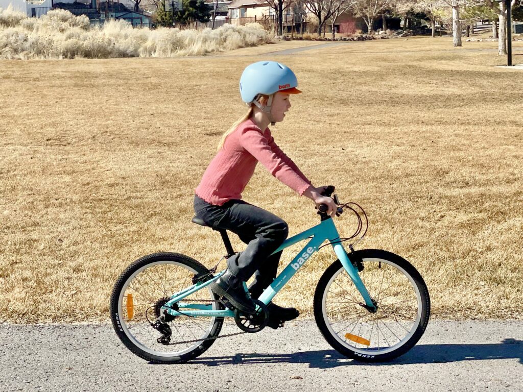 young girl riding a blue base bike 20 inch bike
