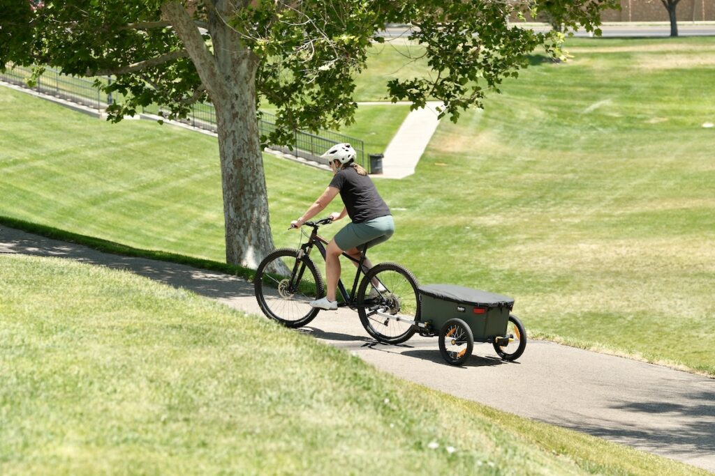 Burley Hopper being pulled up a hill behind a bike