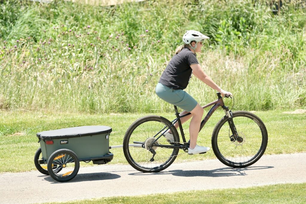 burley hopper cargo trailer being pulled behind a bike