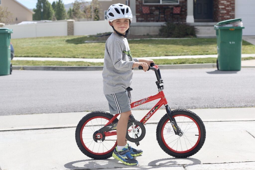 child riding a cheap kids bike with tall handlebars