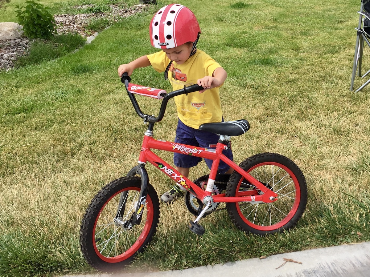 child trying to ride the next rocket 16 inch bike